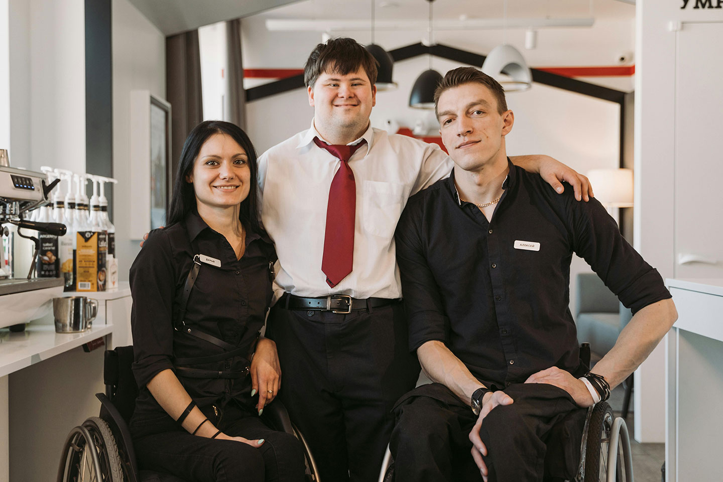 Friends at work in a cafe with various disabilities using & not using wheelchairs