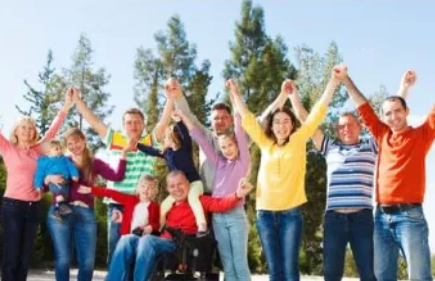 Group of people with and without visual disabilities raising their arms in the air