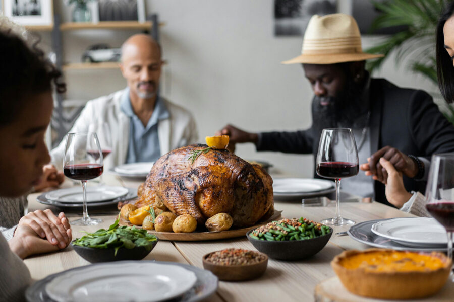 holding hands around the thanksgiving table praying